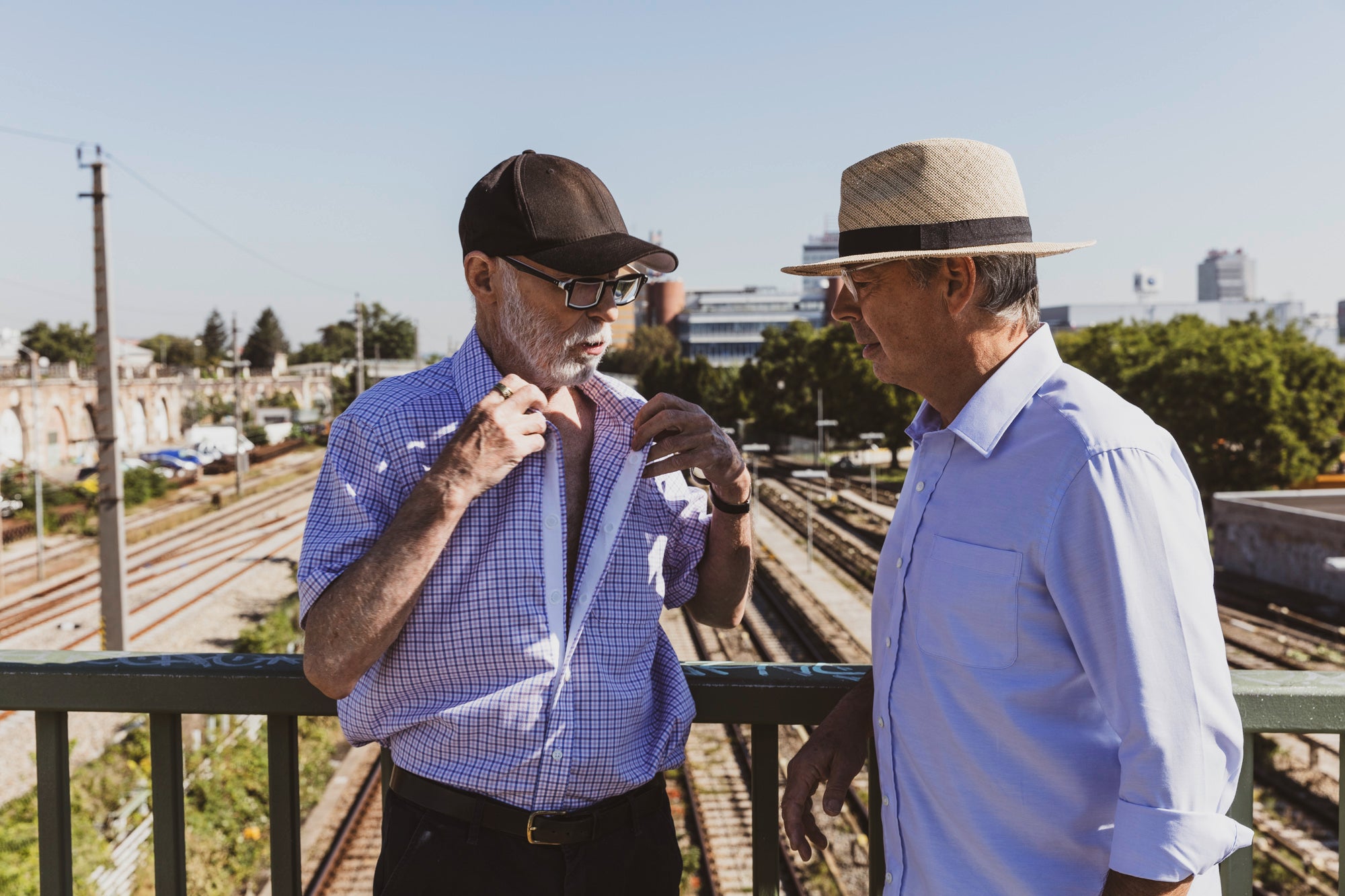 2 Herren öffnen das Magnethemd auf einer Brücke